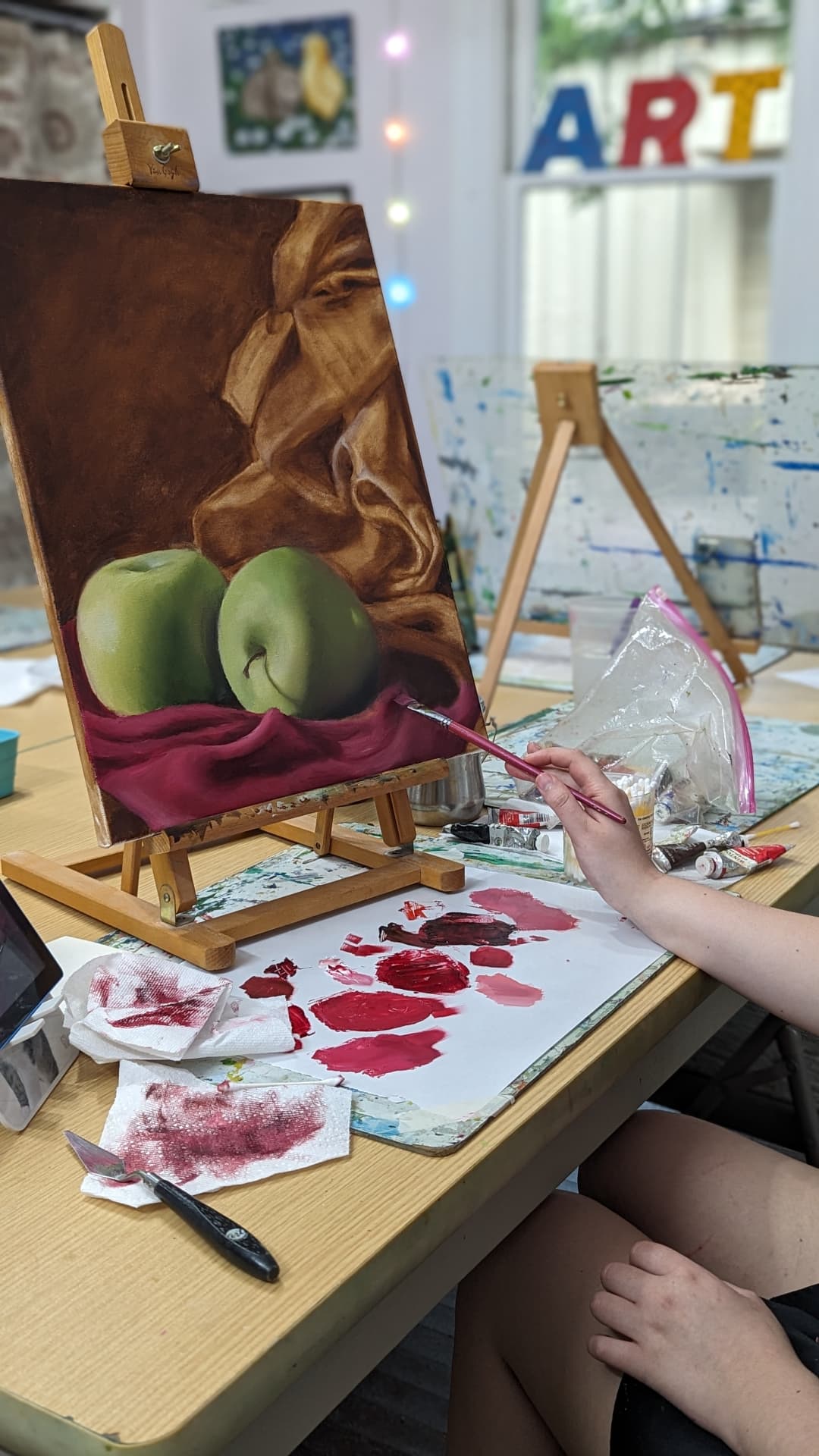 Adult student oil painting green apples on satin, in progress