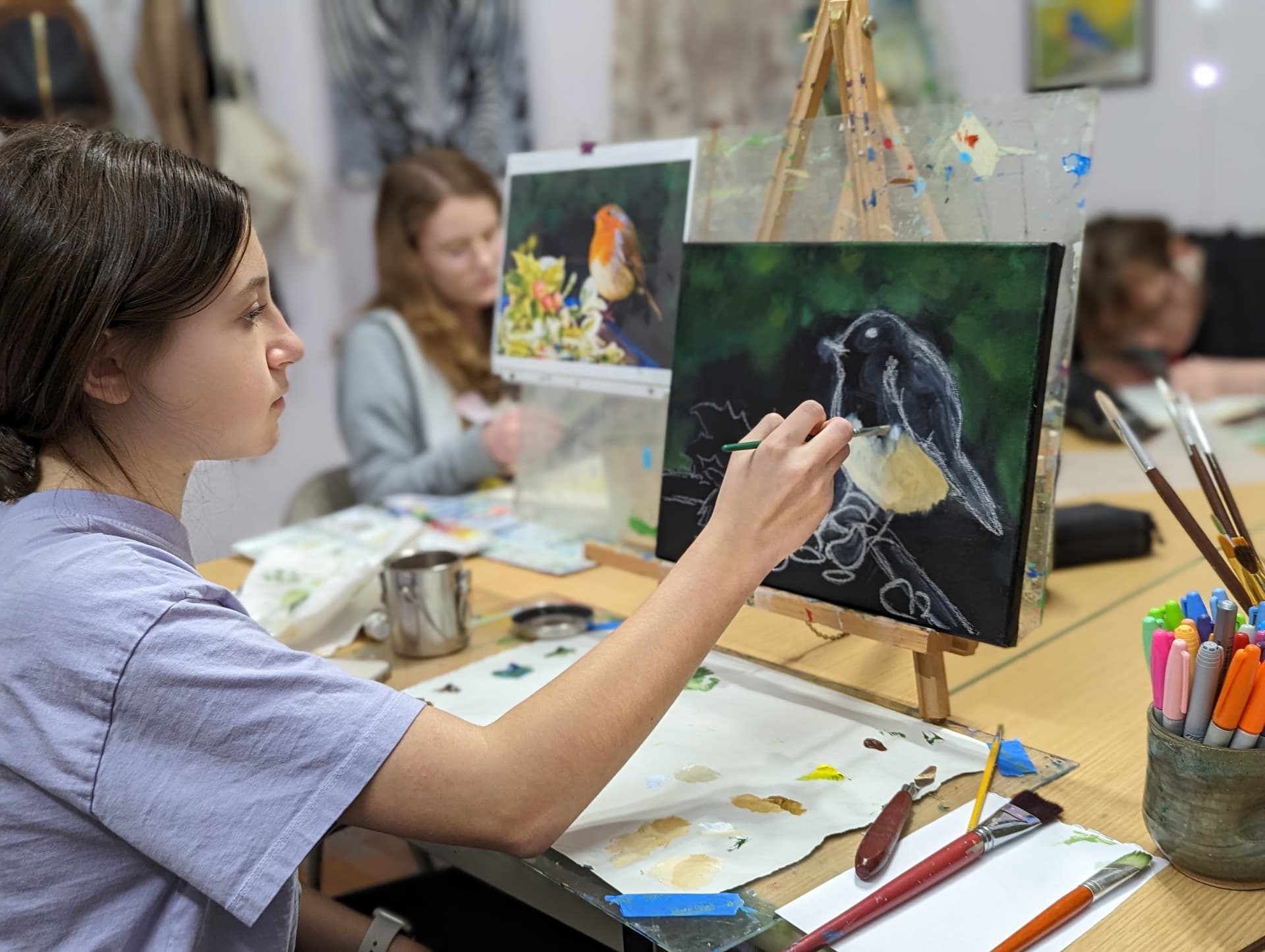 Student painting a portrait in the studio