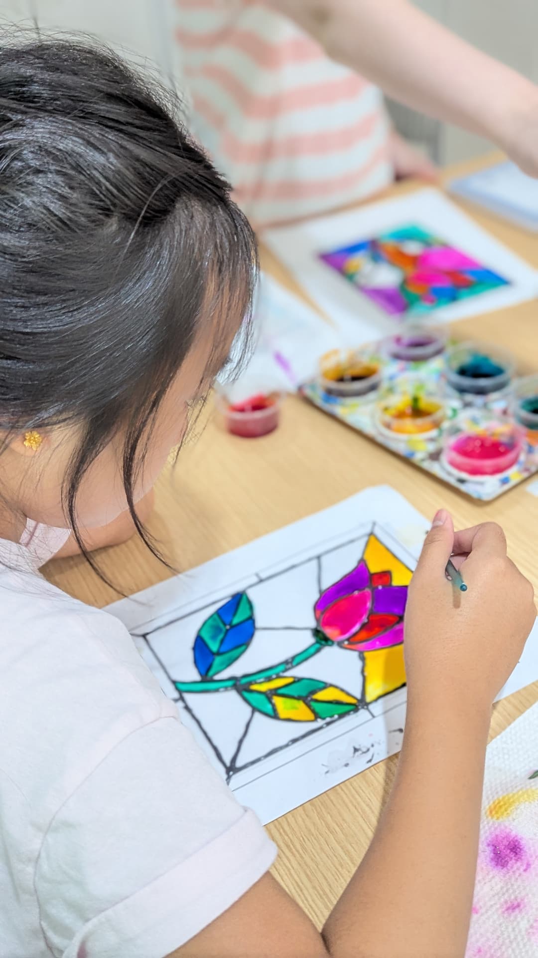Young student painting a stained-glass tulip design