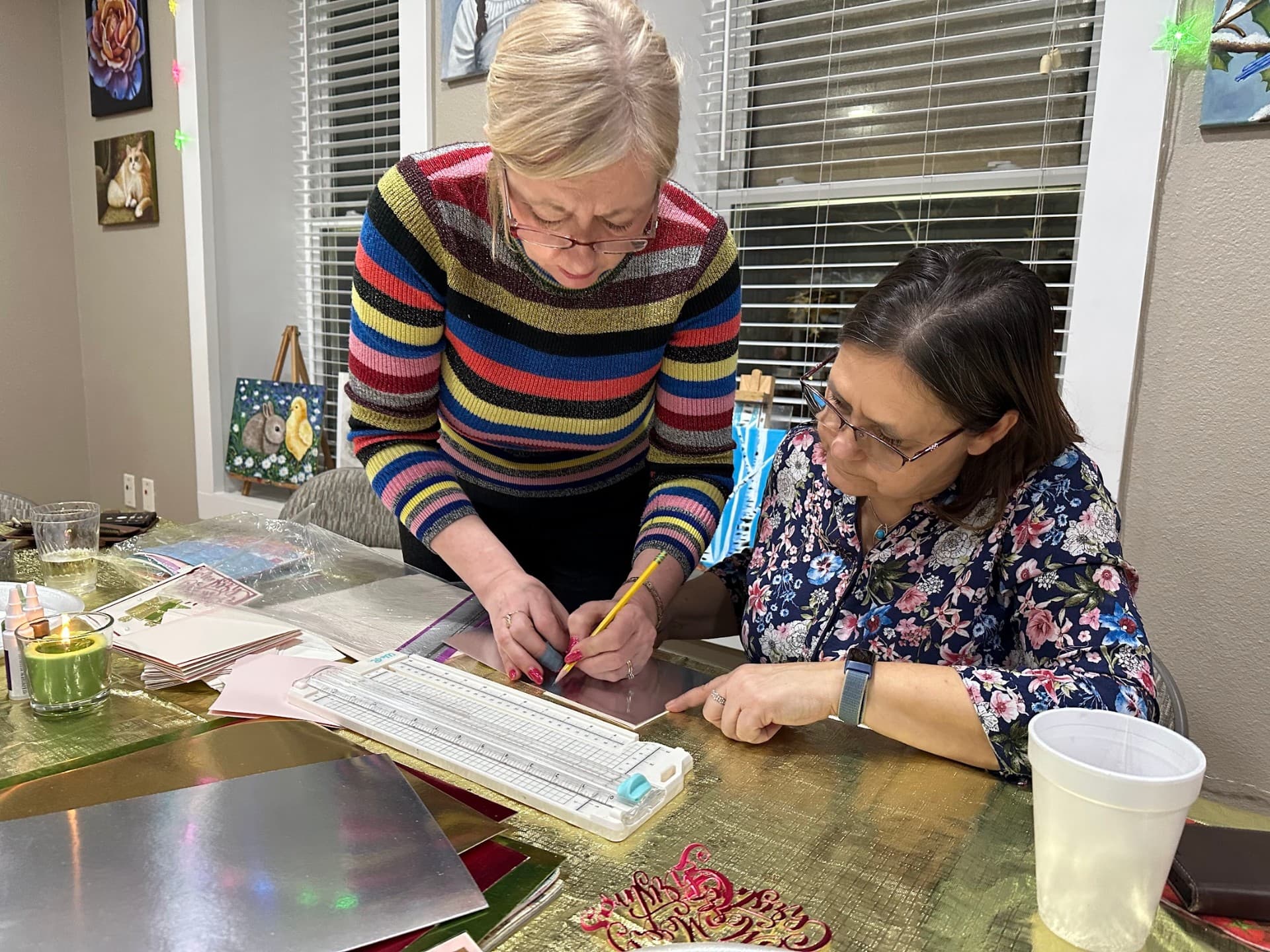 Iwona demonstrating a painting technique to a sip and paint guest