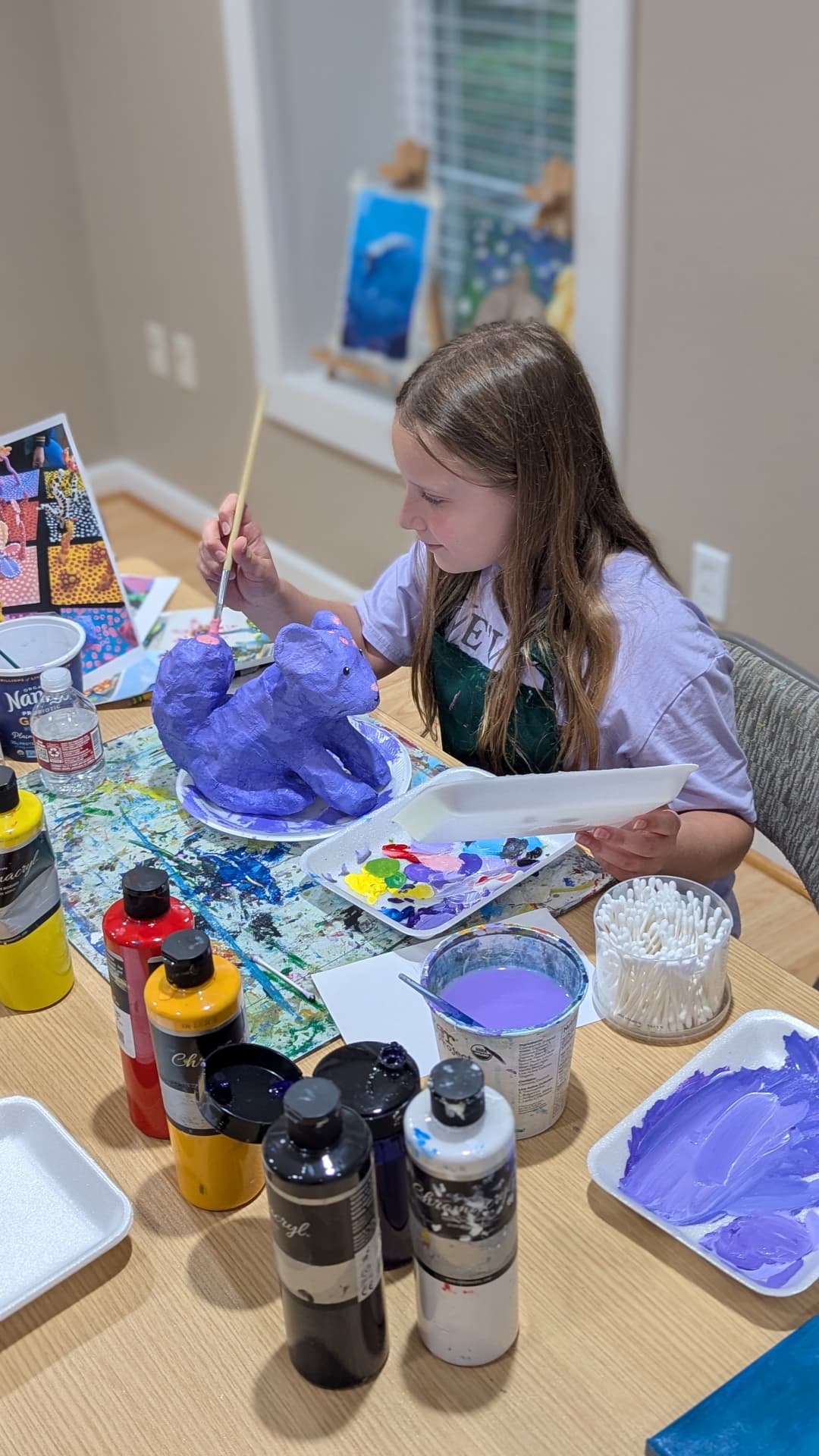 Student painting a clay sculpture