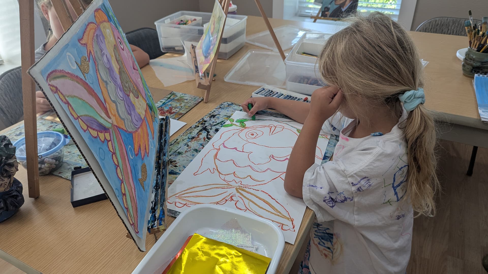 Young student drawing a bird in oil pastel